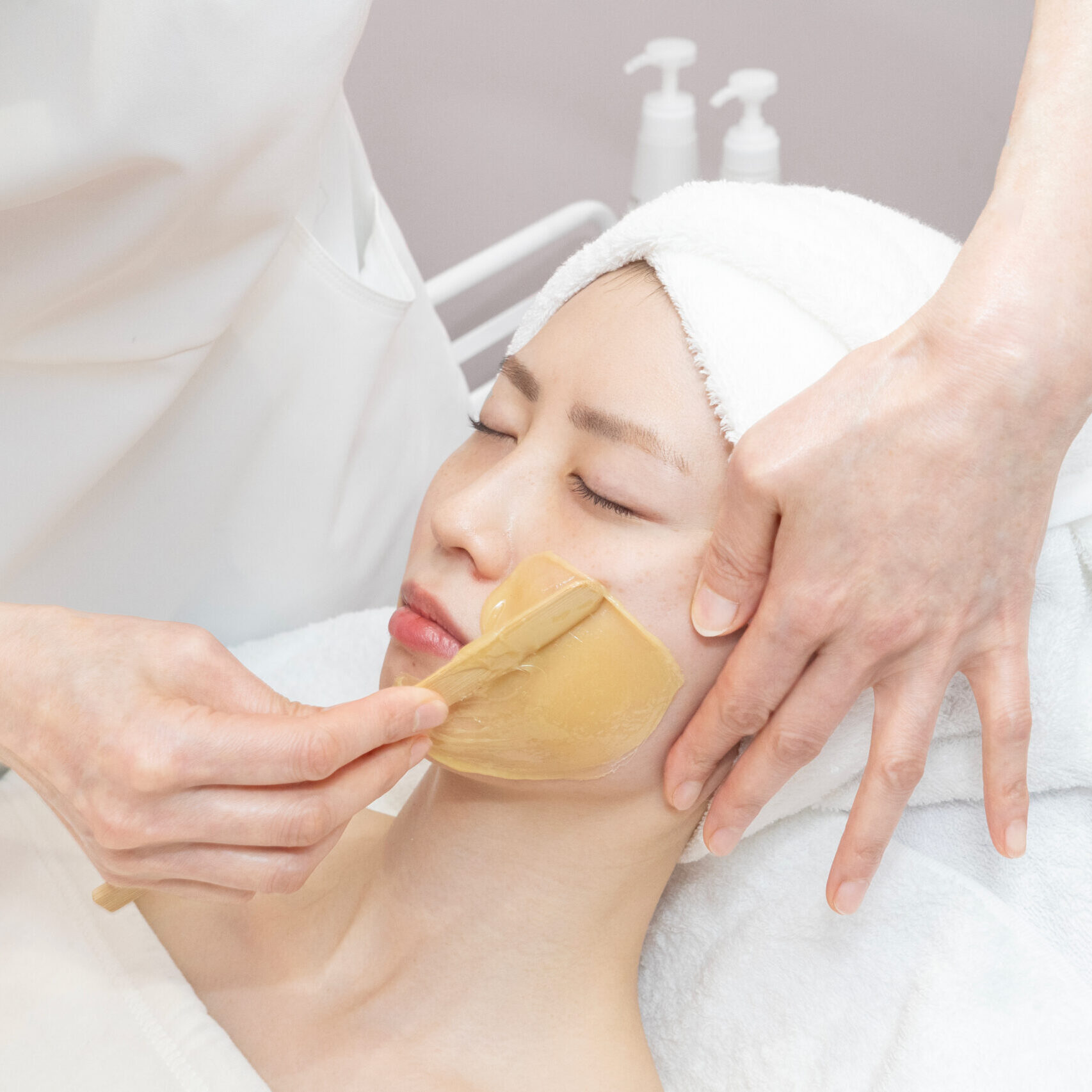 Client receiving the BioWarmy Facial Peel treatment at Oo Spa, comfortably reclining on a treatment bed while enjoying the rejuvenating process with natural ingredients."